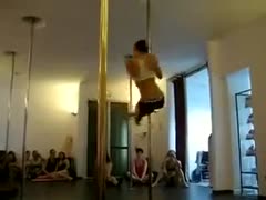 A gorgeous brunette with sexy hair glides sensuously on a pole.